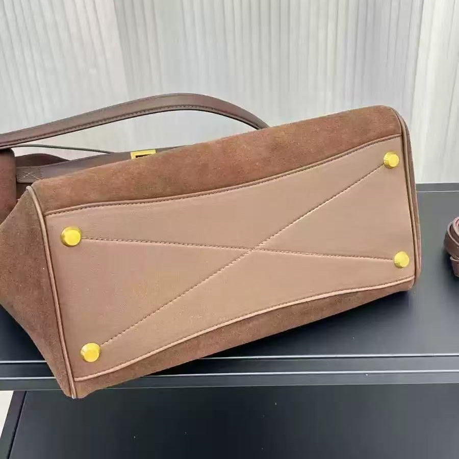 Brown handbag with yellow buttons on a reflective surface