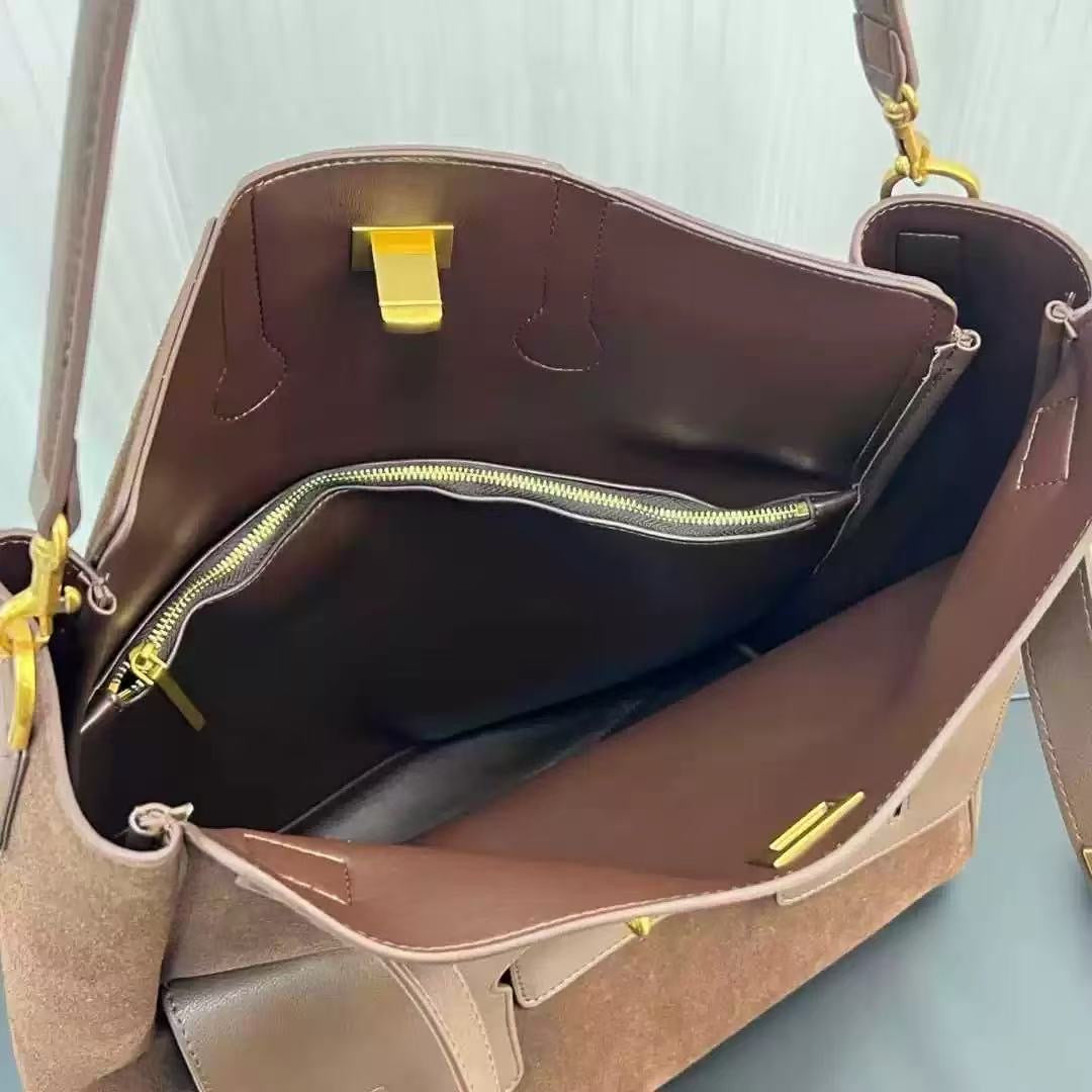 Brown leather handbag with open top, showing interior and zipper details.