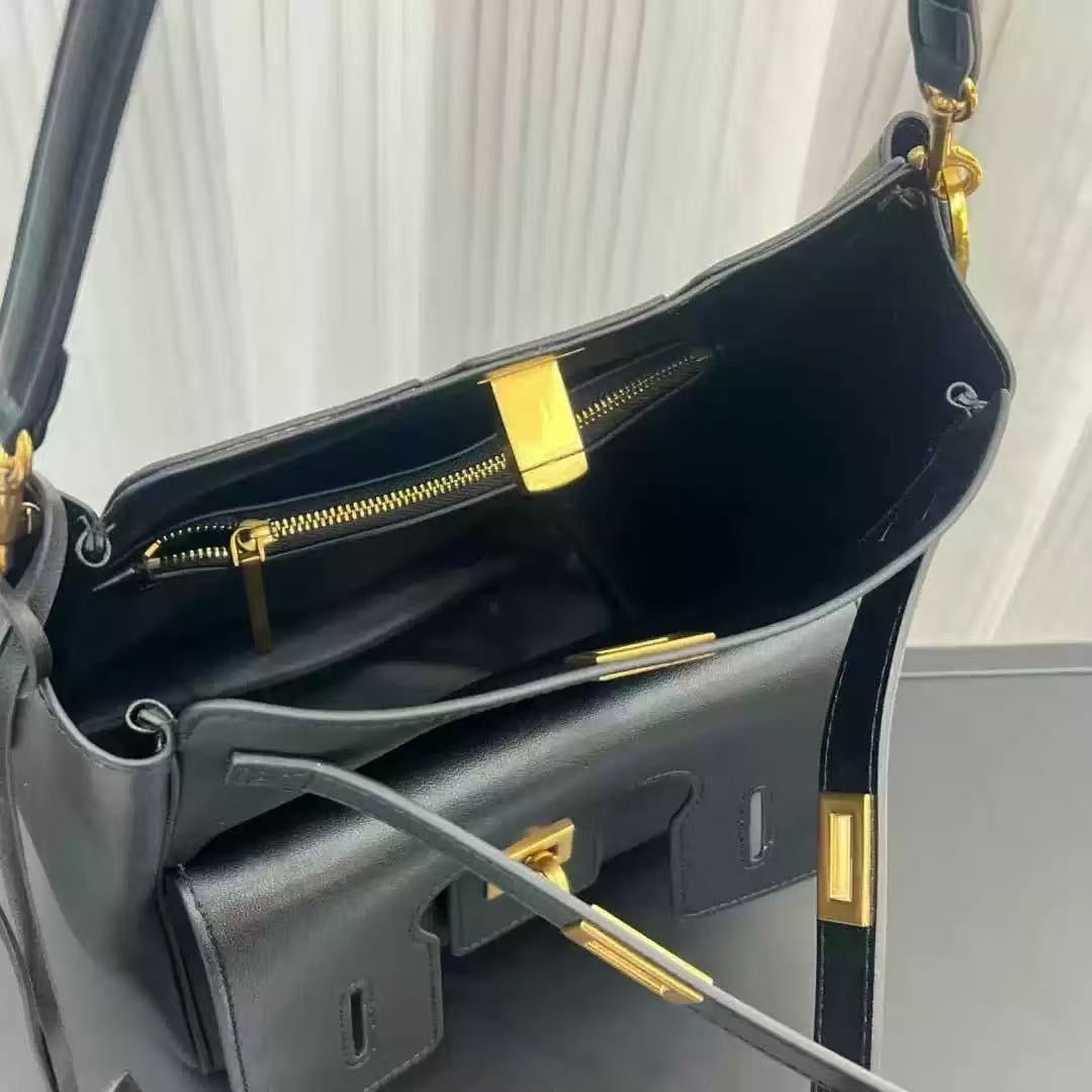Black handbag with gold accents on a light gray background