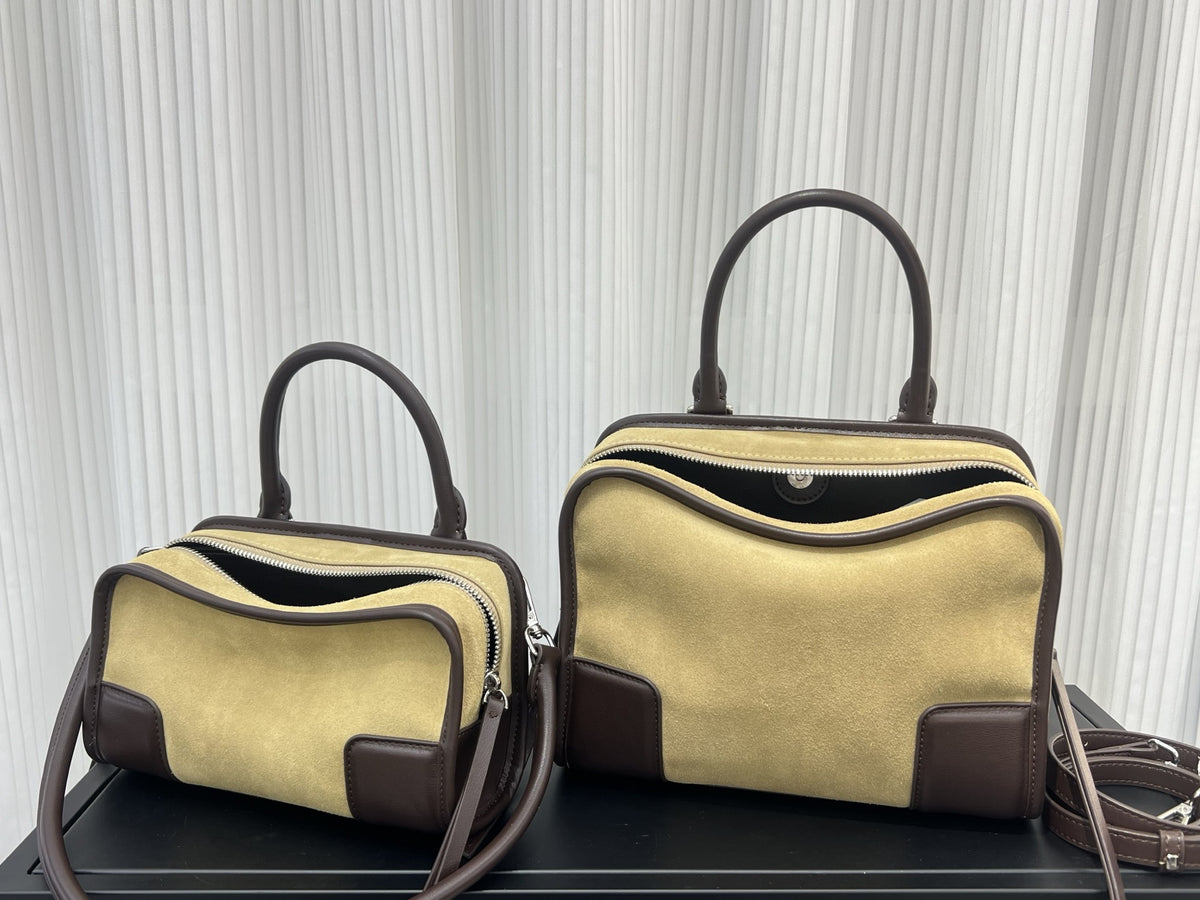 Two beige handbags with brown accents on a black surface against a white textured background