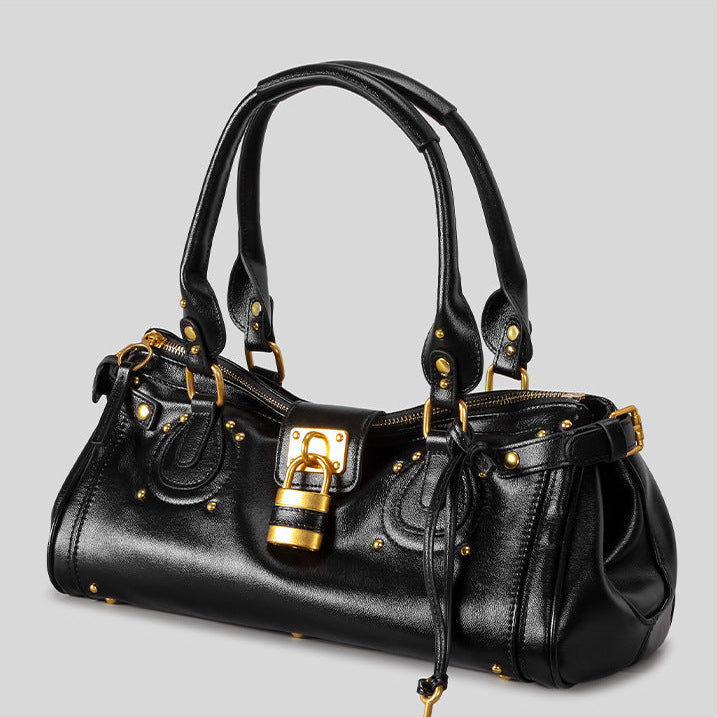 Black handbag with gold accents on a light gray background