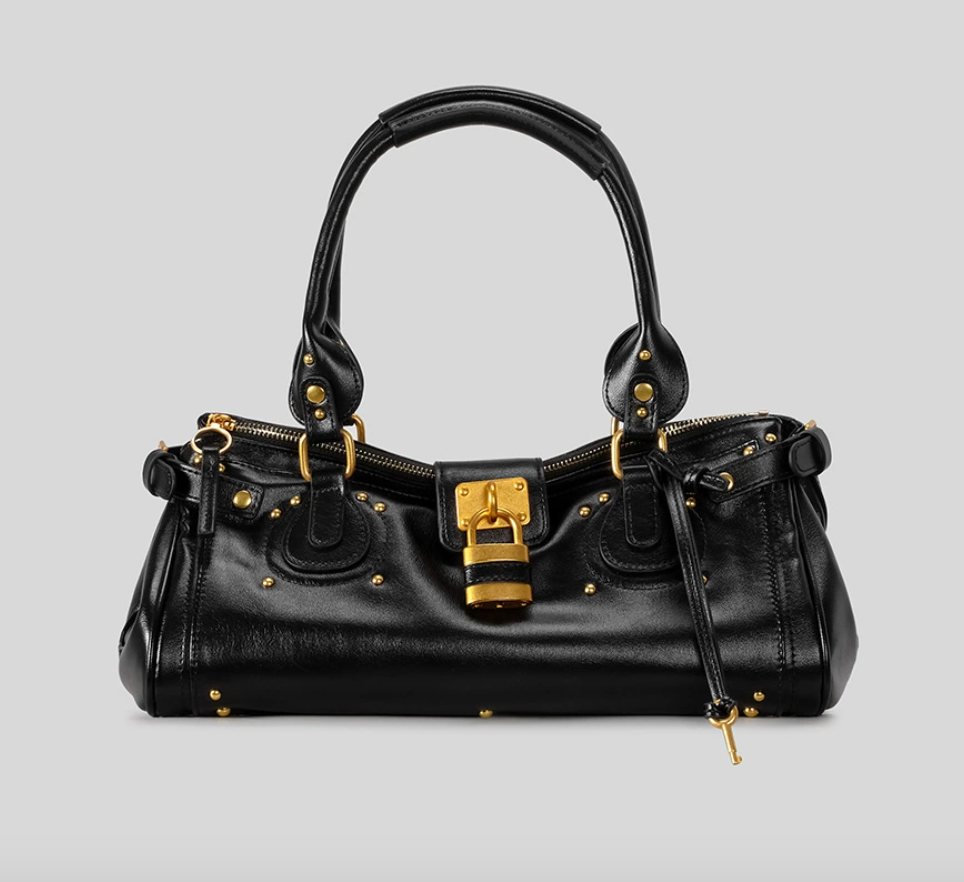 Black handbag with gold accents on a light gray background