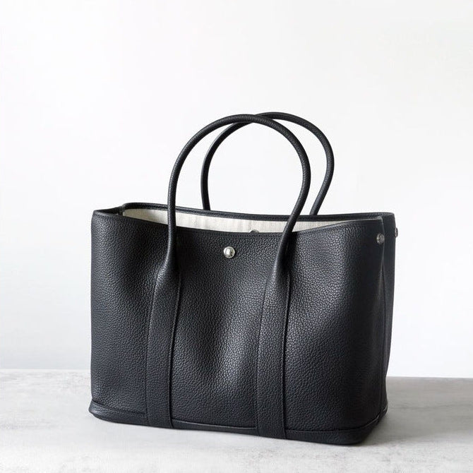 Black leather tote bag on a white background