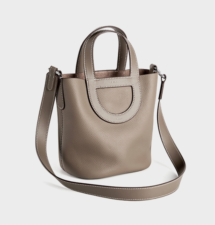 Gray handbag with a shoulder strap on a light gray background