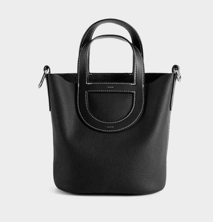 Black handbag with a handle on a light gray background