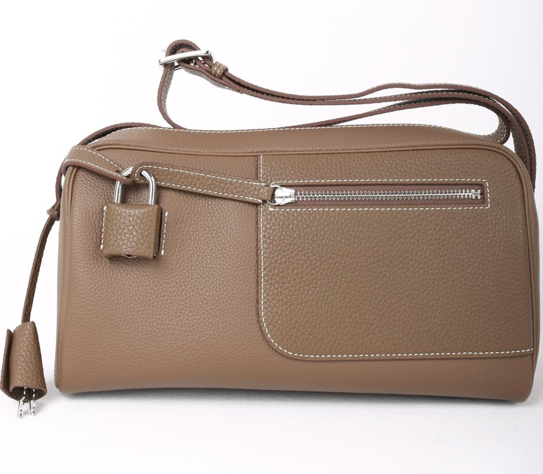 Brown leather handbag with a strap on a white background