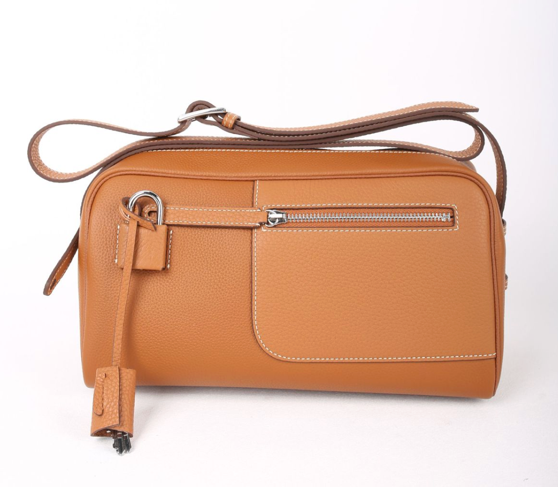 Tan leather handbag with a shoulder strap on a white background