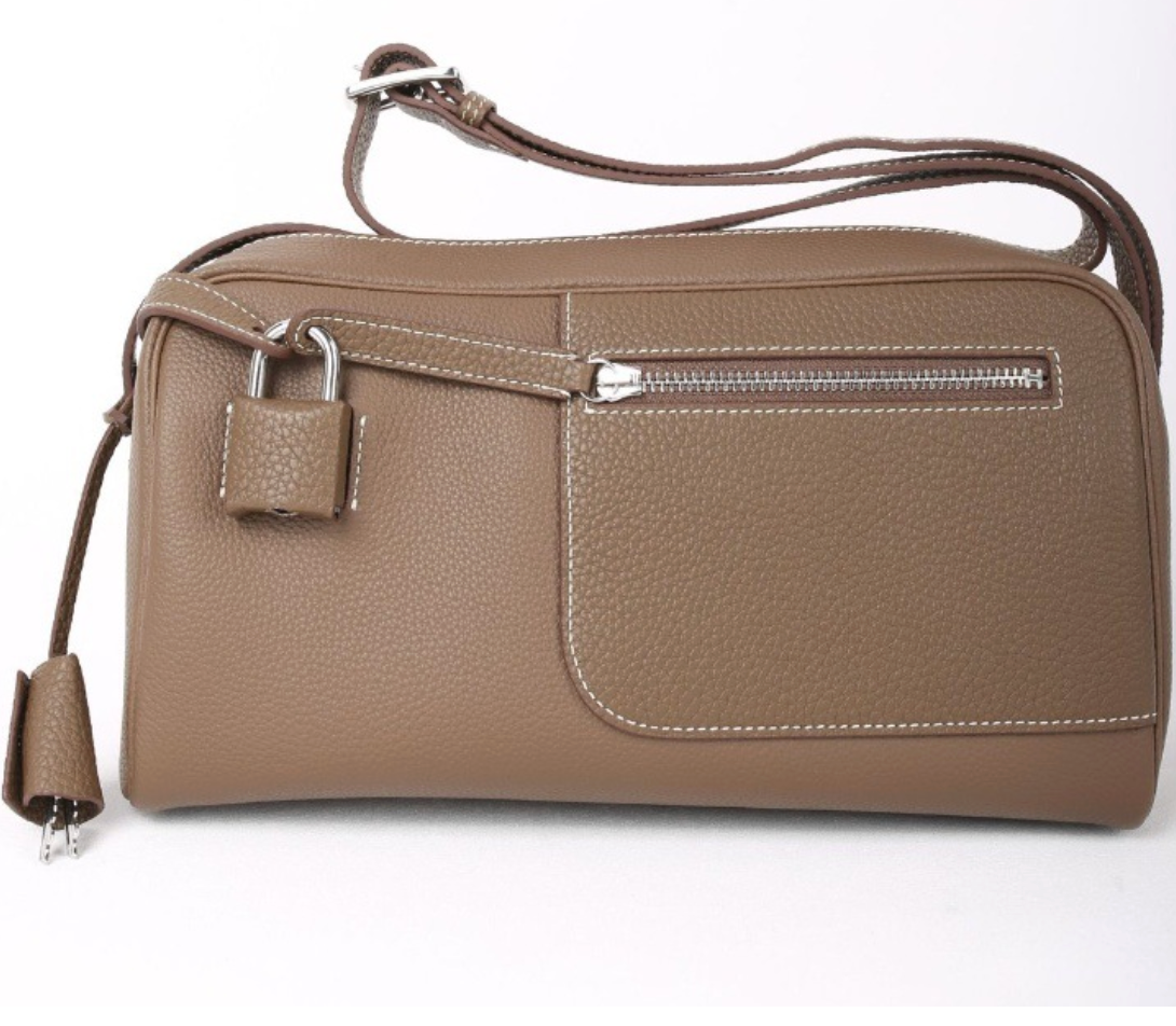 Brown leather handbag with a strap on a white background