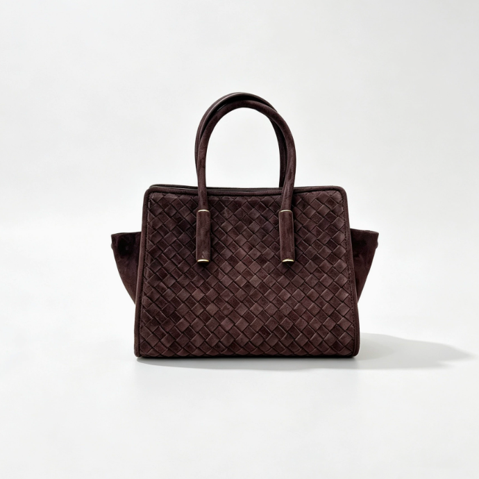 A dark brown woven leather handbag with double top handles and a structured rectangular silhouette, photographed against a clean white studio background.