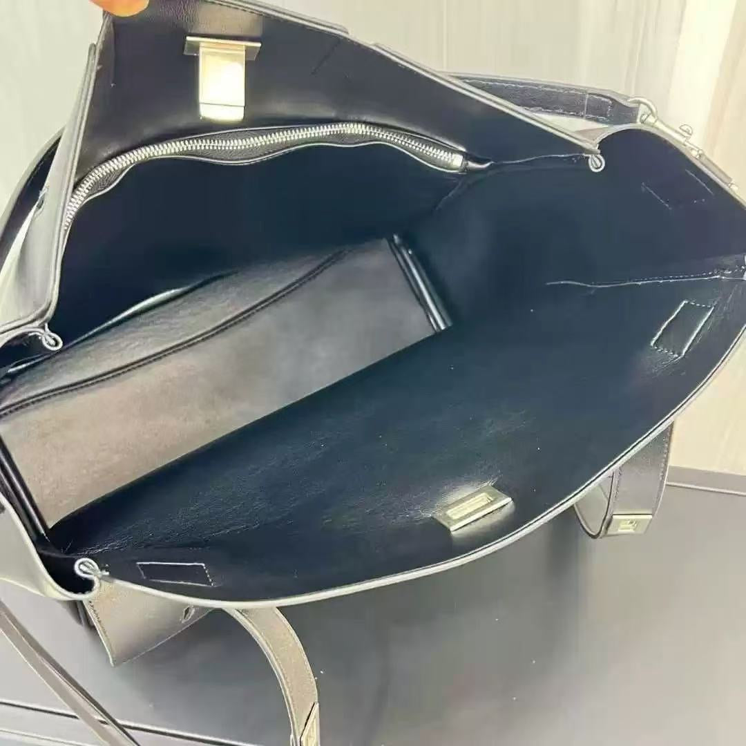 Black handbag with a silver zipper on a light gray background