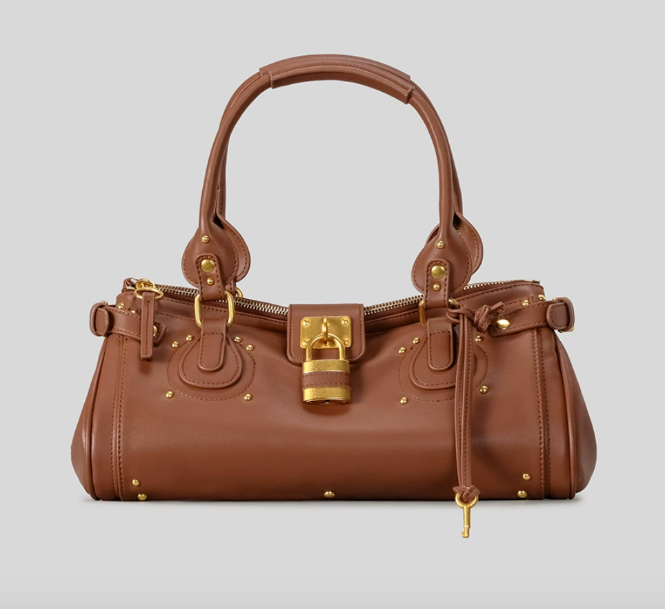 Brown handbag with gold accents on a light gray background