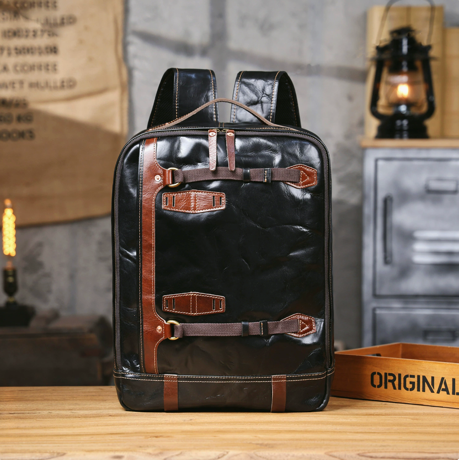 Black leather backpack with brown accents on a wooden surface, rustic background