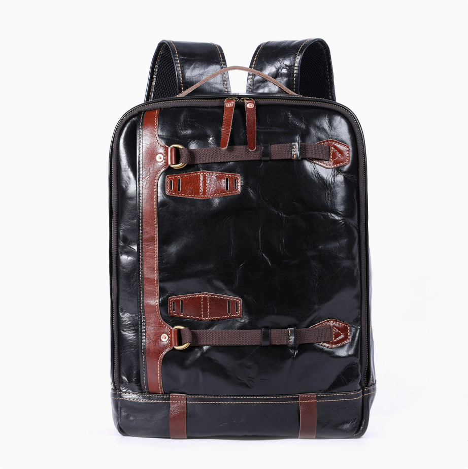 Black leather backpack with brown straps on a white background