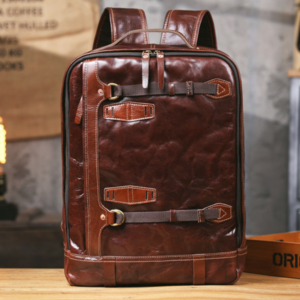 Brown leather backpack on a wooden surface with a rustic background